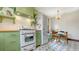 Well-appointed kitchen showcases retro appliances, bright green cabinetry, and a quaint dining nook at 310 S Osprey Ave, Sarasota, FL 34236