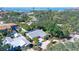 Captivating aerial view of a property with lush surroundings, a tennis court, and a glimpse of the bay at 3530 Flores Ave, Sarasota, FL 34239