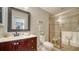 Bright bathroom featuring a vanity with sink, toilet, and glass-enclosed shower with neutral tiling at 3530 Flores Ave, Sarasota, FL 34239