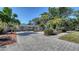 Beautiful single-story home with a brick-paved driveway, complemented by lush landscaping, palm trees and well-maintained curb appeal at 3530 Flores Ave, Sarasota, FL 34239