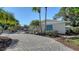 Charming home exterior with a brick driveway, lush landscaping, and a welcoming facade at 3530 Flores Ave, Sarasota, FL 34239