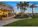 Landscaped backyard features a patio, manicured garden, and outdoor bar under a covered balcony at 364 El Greco Dr, Osprey, FL 34229