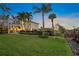 Lush backyard with manicured lawn, tropical landscaping, and a private boat dock at 364 El Greco Dr, Osprey, FL 34229