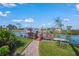 Landscaped backyard featuring a wooden dock and canal access at 364 El Greco Dr, Osprey, FL 34229