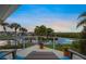 Tranquil view from the balcony of a home overlooking the canal, boats, and tropical landscaping at 364 El Greco Dr, Osprey, FL 34229