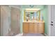 Mint green bathroom has a shower with glass door, marble floors and light wood vanity at 364 El Greco Dr, Osprey, FL 34229
