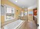 Bright bathroom features a soaking tub, large glass shower, and a window overlooking the neighborhood at 364 El Greco Dr, Osprey, FL 34229