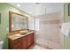 Bathroom boasts a granite vanity, wood cabinetry and tiled walk-in shower with glass enclosure at 364 El Greco Dr, Osprey, FL 34229