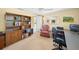 Carpeted bedroom features a ceiling fan, wooden desk and a bookshelf filled with books at 364 El Greco Dr, Osprey, FL 34229