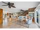 Spacious living room with travertine floors, neutral paint, fireplace, staircase, and lots of natural light at 364 El Greco Dr, Osprey, FL 34229