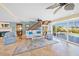 Bright living room with views of pool, cozy seating, fireplace, travertine floors, and large sliding glass doors at 364 El Greco Dr, Osprey, FL 34229