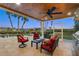 Relaxing covered patio with an outdoor kitchen, seating, and beautiful views of the pool and tropical landscaping at 364 El Greco Dr, Osprey, FL 34229