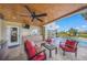 Covered patio includes a ceiling fan, TV, seating, outdoor kitchen, and a view of the pool at 364 El Greco Dr, Osprey, FL 34229