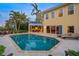 Backyard oasis featuring a sparkling pool, palm trees, and a covered patio at 364 El Greco Dr, Osprey, FL 34229