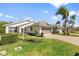 Charming home featuring a two-car garage, well-manicured lawn, and beautiful palm trees against a clear blue sky at 4528 Fern Dr, Bradenton, FL 34208