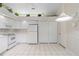 Bright kitchen features white cabinets, appliances and tile floor, plus an elevated display shelf for plants and decor at 4528 Fern Dr, Bradenton, FL 34208
