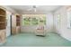 Inviting sunroom featuring comfortable armchair, large windows with wooded views, and built in shelving at 4528 Fern Dr, Bradenton, FL 34208