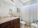 A bathroom with a wood vanity and a shower/tub combo with a shower curtain at 5821 Hevena Ct, Palmetto, FL 34221