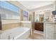 Bright bathroom features a soaking tub, glass shower, and double vanity with granite countertops at 5821 Hevena Ct, Palmetto, FL 34221