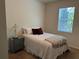 A neutral tone bedroom with a cozy bed and side table, with natural light from the window at 5821 Hevena Ct, Palmetto, FL 34221