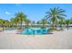 Stunning community pool with sparkling water, surrounded by palm trees and comfortable lounge chairs under a clear blue sky at 5821 Hevena Ct, Palmetto, FL 34221