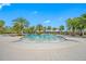 Gorgeous community pool featuring shallow wading area, palm trees, seating, and ample space for relaxation and enjoyment at 5821 Hevena Ct, Palmetto, FL 34221