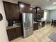 A kitchen showcasing stainless appliances, dark wood cabinets, granite countertops and tile flooring at 5821 Hevena Ct, Palmetto, FL 34221