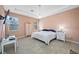 Bright main bedroom featuring a tray ceiling, carpeted floors, two windows, and ample space at 5821 Hevena Ct, Palmetto, FL 34221