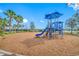 Bright and colorful playground with slides, swings, and climbing structures, set on a wood chip surface with a view of the lake at 5821 Hevena Ct, Palmetto, FL 34221