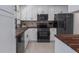 Modern kitchen featuring white cabinetry, wood countertops, and sleek black appliances at 6705 20Th W Ave, Bradenton, FL 34209