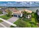 Stunning lakefront home features lush landscaping, tile roof, and a paver driveway at 7760 Grande Shores Dr, Sarasota, FL 34240