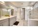 Well-lit bathroom with double vanity, a marble shower, and neutral color tones at 7760 Grande Shores Dr, Sarasota, FL 34240