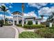 Community clubhouse featuring a covered entrance, lush landscaping, and well-maintained exterior at 7760 Grande Shores Dr, Sarasota, FL 34240