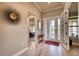 Bright foyer features wood-look tile floors, a decorative mirror, and a glass front door at 7760 Grande Shores Dr, Sarasota, FL 34240