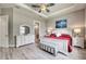 Inviting main bedroom featuring a tray ceiling, accent lighting, and a view of the en suite bathroom at 7760 Grande Shores Dr, Sarasota, FL 34240