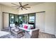 Relax on this inviting patio featuring comfortable seating and scenic views through sliding glass doors at 7760 Grande Shores Dr, Sarasota, FL 34240