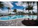 Large community pool surrounded by palm trees and lounge chairs for relaxation at 7760 Grande Shores Dr, Sarasota, FL 34240