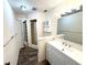 Well-lit bathroom featuring a modern vanity, mirror, and storage shelves at 1022 De Soto Dr, Dunedin, FL 34698
