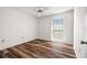 Simple bedroom with wood flooring, window, and a ceiling fan at 1022 De Soto Dr, Dunedin, FL 34698