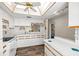 Well-lit kitchen boasting white cabinets, tile countertops, and wood-look floors at 1022 De Soto Dr, Dunedin, FL 34698