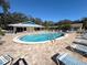 Community pool area offering a clubhouse, ample seating, and a clear blue pool at 1022 De Soto Dr, Dunedin, FL 34698