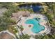Aerial view of a resort-style pool area with a splash pad, lounging chairs, and meticulously landscaped grounds at 12810 Daisy Pl, Bradenton, FL 34212