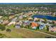 Neighborhood aerial view featuring a pond, many houses, and lush greenery, under a blue sky at 12810 Daisy Pl, Bradenton, FL 34212