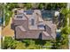 Aerial view of a home featuring solar panels, a screened-in pool, lush greenery, and a brick driveway at 12810 Daisy Pl, Bradenton, FL 34212