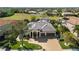 Stunning aerial view of a luxurious home with lush landscaping, a paver driveway, and a tile roof at 12810 Daisy Pl, Bradenton, FL 34212