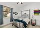 Cozy bedroom featuring a black iron bed frame, ceiling fan and a window with charming curtains at 12810 Daisy Pl, Bradenton, FL 34212