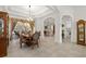Open-concept dining room showcasing an elegant chandelier, wood table and seamless access to kitchen and pool area at 12810 Daisy Pl, Bradenton, FL 34212