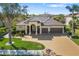 Beautiful home featuring a well-maintained lawn, mature trees, and a spacious driveway leading to a three-car garage at 12810 Daisy Pl, Bradenton, FL 34212