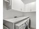 Functional laundry room featuring built-in cabinets, ample countertop space, and modern washer/dryer units at 12810 Daisy Pl, Bradenton, FL 34212