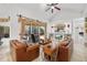 Comfortable living room with plush leather sofas, a ceiling fan, and access to the outdoor pool area at 12810 Daisy Pl, Bradenton, FL 34212
